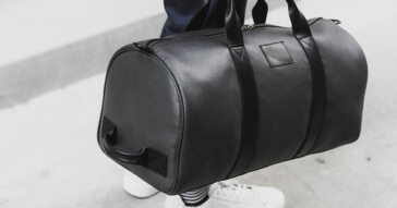 Eine elegante schwarze Unisex Sporttasche aus Leder, ideal für Reisen und Sport.